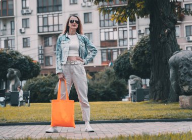 Şehrin arka planında keten çantalı güzel bir kadın..
