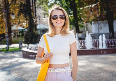 Şehrin arka planında keten çantalı güzel bir kadın..