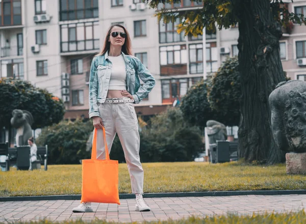 Şehrin arka planında keten çantalı güzel bir kadın..