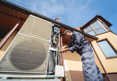 HVAC teknisyeni evde ısıtma ve soğutma sistemi hizmeti veriyor.