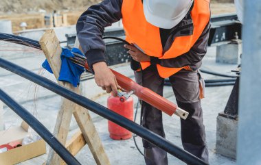 Yüksek voltajlı kablo döşeyen iki elektrikçi işçi