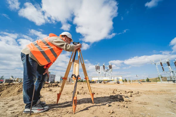 Undersökare arbetare med teodolitutrustning på byggarbetsplatsen — Stockfoto