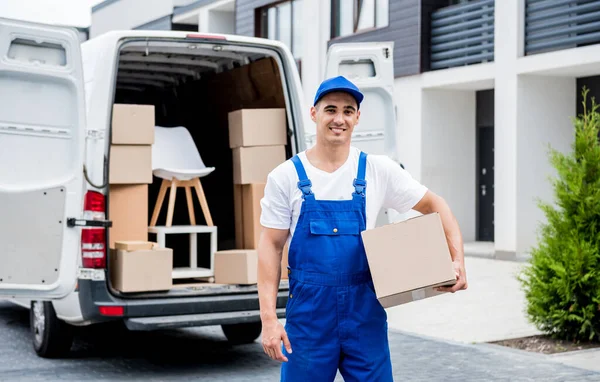 Removal company worker unloading boxes from minibus into customers home — Stock Photo, Image