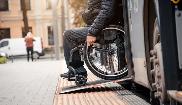 La persona con disabilità fisica esce dal trasporto pubblico con una rampa accessibile. — Foto Stock