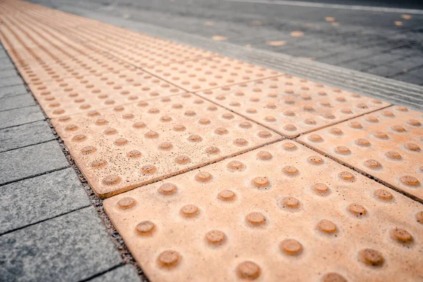 Gele brailleblokken op openbaar vervoersstation voor personen met een lichamelijke beperking — Stockfoto