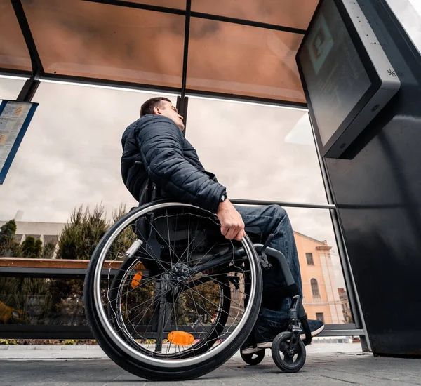 Persona con disabilità fisica in attesa di trasporto urbano con rampa accessibile. — Foto Stock