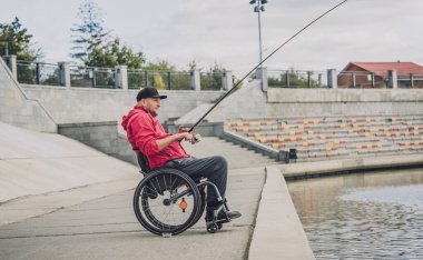Tekerlekli sandalyede balıkçı teknesinde fiziksel engelli biri..