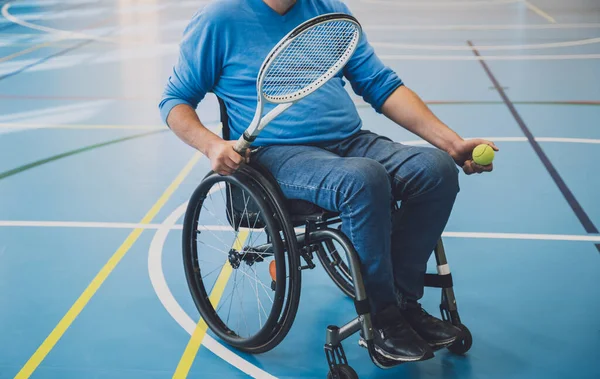 Erwachsener Mann mit körperlicher Behinderung im Rollstuhl spielt Tennis auf Tennishalle — Stockfoto