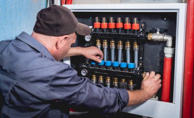 HVAC teknisyeni evde ısıtma ve soğutma sistemi hizmeti veriyor.