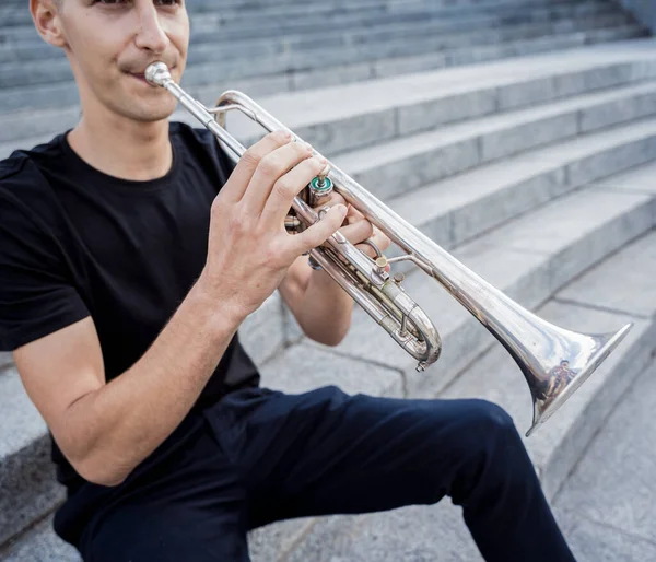 Jeune musicien de rue jouant de la guitare assis sur des marches de granit — Photo