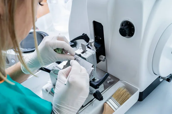 Asistente de laboratorio trabaja en una sección de microtoma rotatorio y haciendo diapositivas de microscopio —  Fotos de Stock