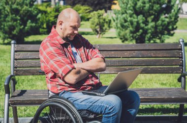 Parkta çalışan, tekerlekli sandalyede fiziksel engelli bir serbest çalışan.