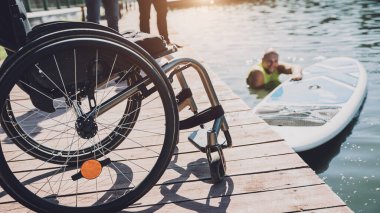 Tekerlekli sandalye kullanan fiziksel engelli kişi yemek masasına oturacak.