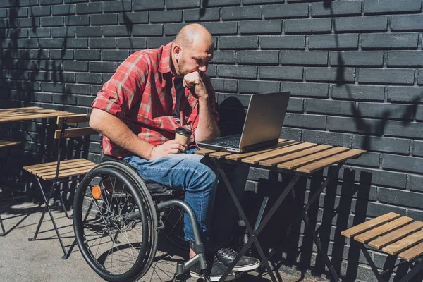 Freelancer con discapacidad física en silla de ruedas que trabaja en la cafetería de la calle —  Fotos de Stock