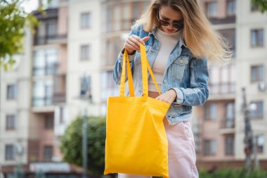 Şehrin arka planında keten çantalı güzel bir kadın..