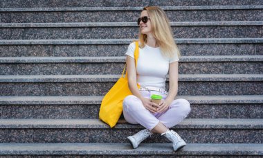 Genç ve güzel bir kadın. Arka planda keten bir çanta var..