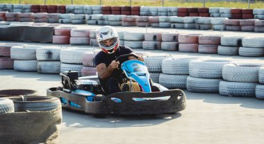 Genç bir adam pistte go kart kullanıyor.