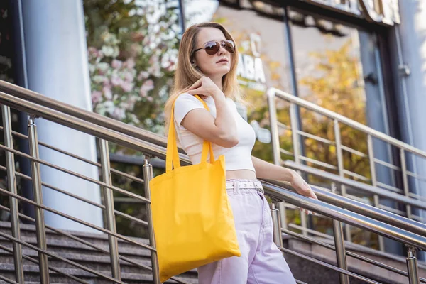 Joven hermosa mujer con bolsa ecológica de lino en el fondo de la ciudad. —  Fotos de Stock