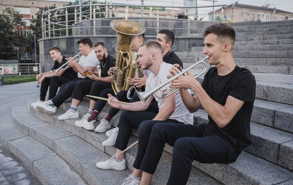 Молодая уличная музыкальная группа играет на многих музыкальных инструментах — стоковое фото