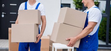 İki nakliye şirketi çalışanı bir minibüse kutu yüklüyorlar..