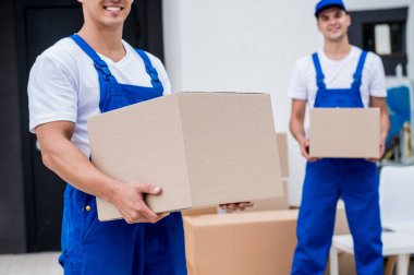 İki nakliye şirketi çalışanı bir minibüse kutu yüklüyorlar..