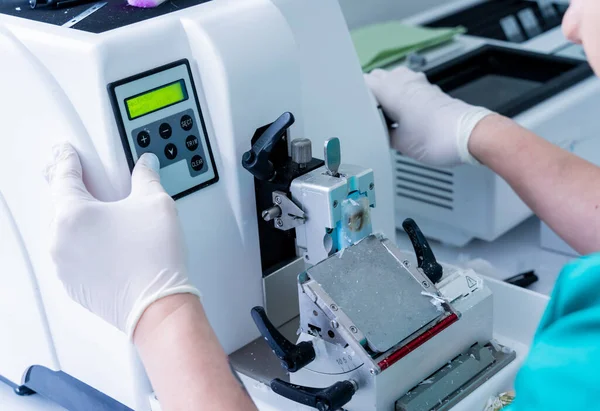 Asistente de laboratorio trabaja en una sección de microtoma rotatorio y haciendo diapositivas de microscopio —  Fotos de Stock