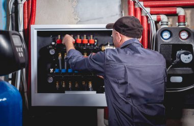 HVAC teknisyeni evde ısıtma ve soğutma sistemi hizmeti veriyor.