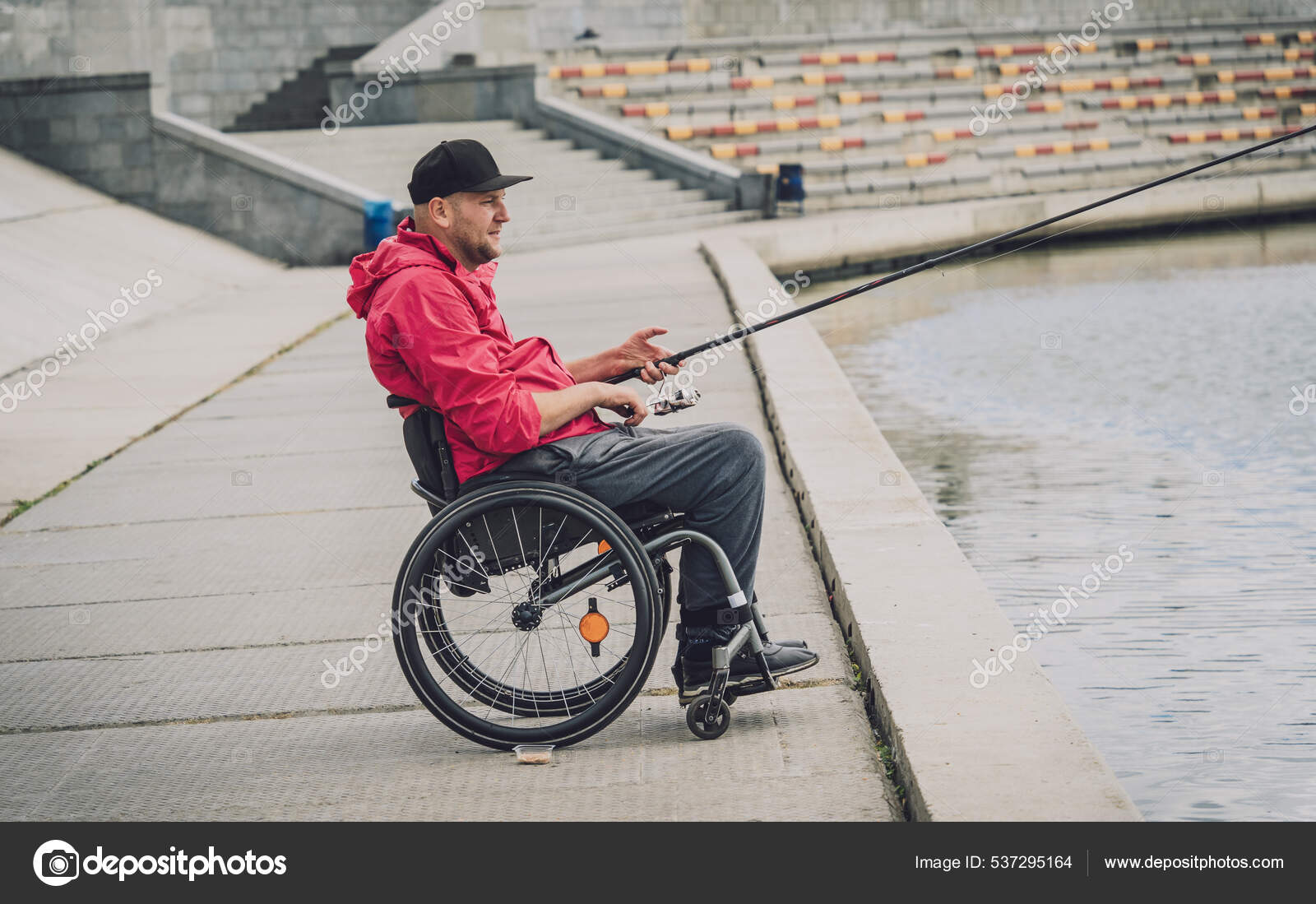 Person with a physical disability who uses wheelchair fishing from fishing  pier. Stock Photo by ©Romaset 537295164