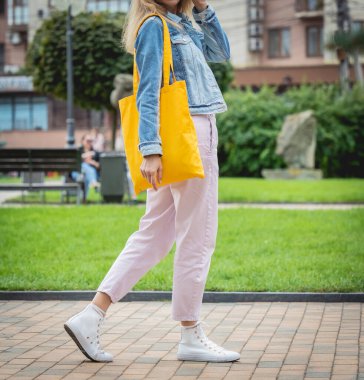 Şehrin arka planında keten çantalı güzel bir kadın..