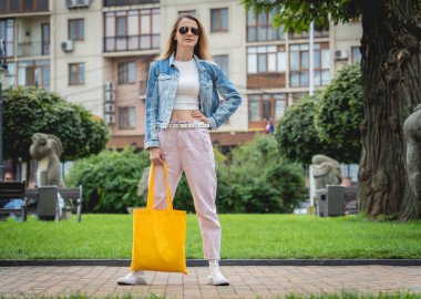 Şehrin arka planında keten çantalı güzel bir kadın..