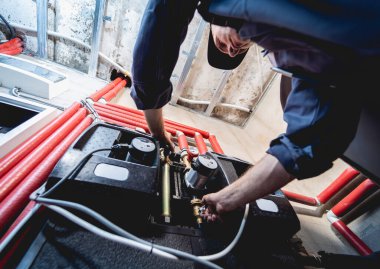 HVAC teknisyeni evde ısıtma ve soğutma sistemi hizmeti veriyor.