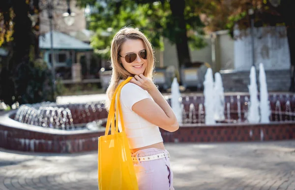 도시 배경에 아마포 가방을 들고 있는 아름다운 소녀. — 스톡 사진