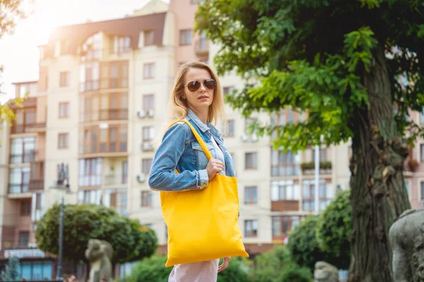 Joven hermosa mujer con bolsa ecológica de lino en el fondo de la ciudad. —  Fotos de Stock
