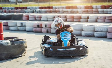 Genç bir adam pistte go kart kullanıyor.