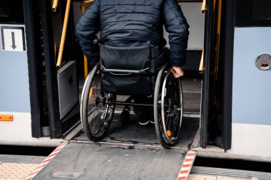 Fiziksel engelli bir kişi erişilebilir bir rampayla toplu taşımaya giriyor.