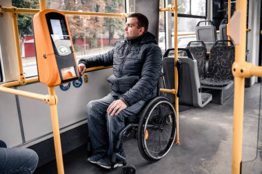 Toplu taşıma araçlarında fiziksel engelli ve erişilebilir rampası olan biri..