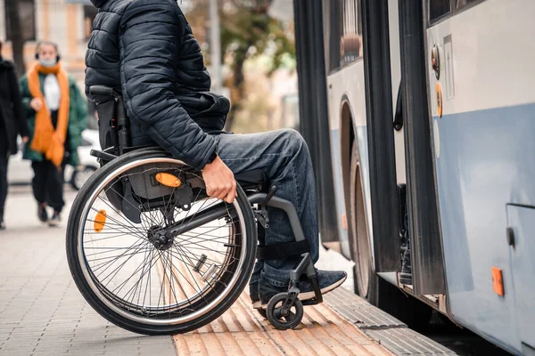 Fiziksel engelli bir kişi erişilebilir bir rampayla toplu taşımaya giriyor.