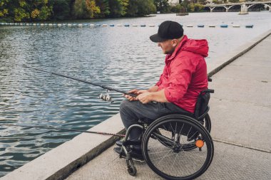 Balıkçı iskelesinden tekerlekli sandalyede balık tutan fiziksel engelli biri..