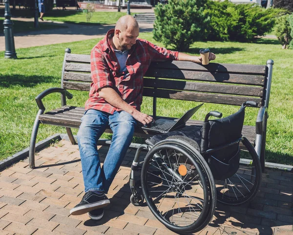 Na volné noze s tělesným postižením, který používá invalidní vozík pracuje v parku — Stock fotografie