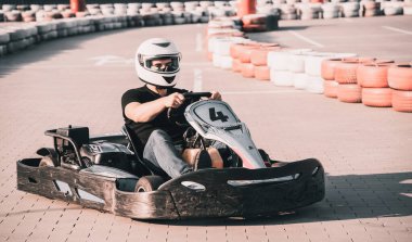 Genç bir adam pistte go kart kullanıyor.