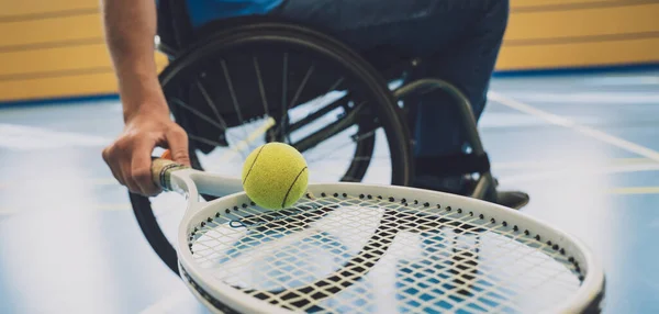 Hombre adulto con discapacidad física que utiliza silla de ruedas jugando al tenis en pista de tenis cubierta —  Fotos de Stock