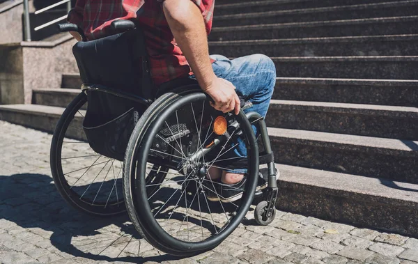 Merdivenlerin önünde tekerlekli sandalye kullanan fiziksel engelli genç bir adam. — Stok fotoğraf