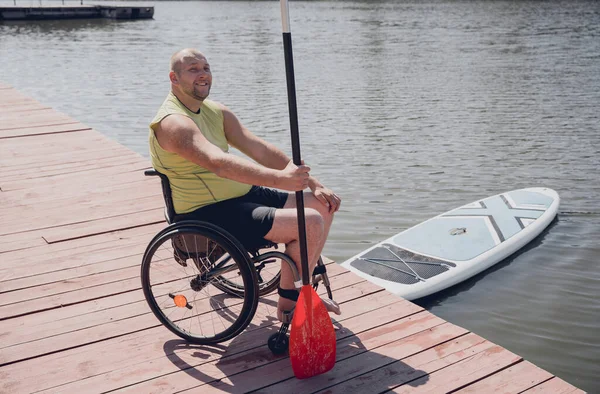 Osoba s tělesným postižením, která používá invalidní vozík bude jezdit na sup boardu — Stock fotografie