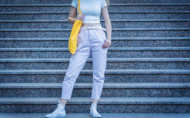 Genç ve güzel bir kadın. Arka planda keten bir çanta var..