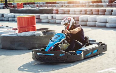 Genç bir adam pistte go kart kullanıyor.