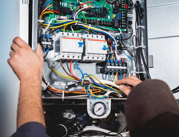 Klima teknisyeni klimayı kontrol ediyor.