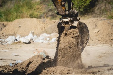Tekerlek yükleyici kazıcı inşaat alanında çalışıyor.
