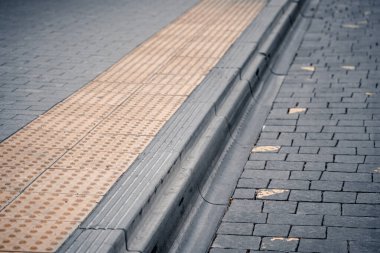 Fiziksel engelli kişiler için toplu taşıma istasyonunda sarı kabartma yazılar