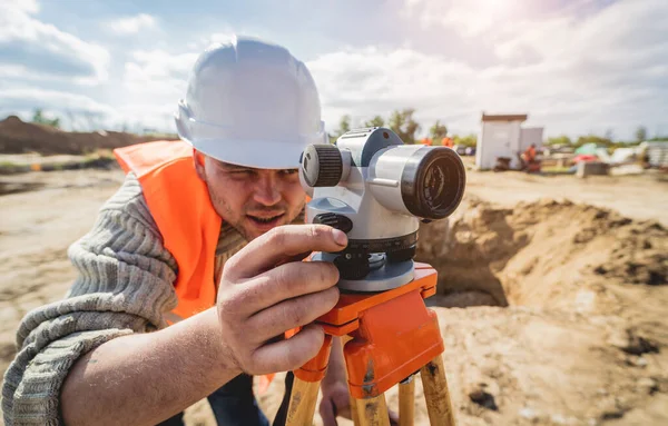 Undersökare arbetare med teodolitutrustning på byggarbetsplatsen — Stockfoto