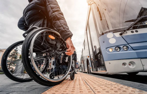 Persona con disabilità fisica in attesa di trasporto urbano con rampa accessibile. — Foto Stock